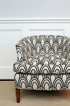 an upholstered chair with black and white art deco fabric on the armrests