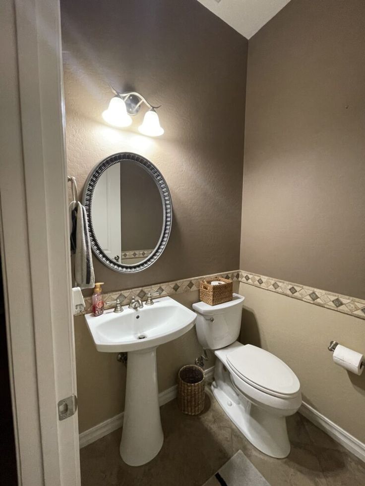 a bathroom with a toilet, sink and mirror in it's corner area is shown