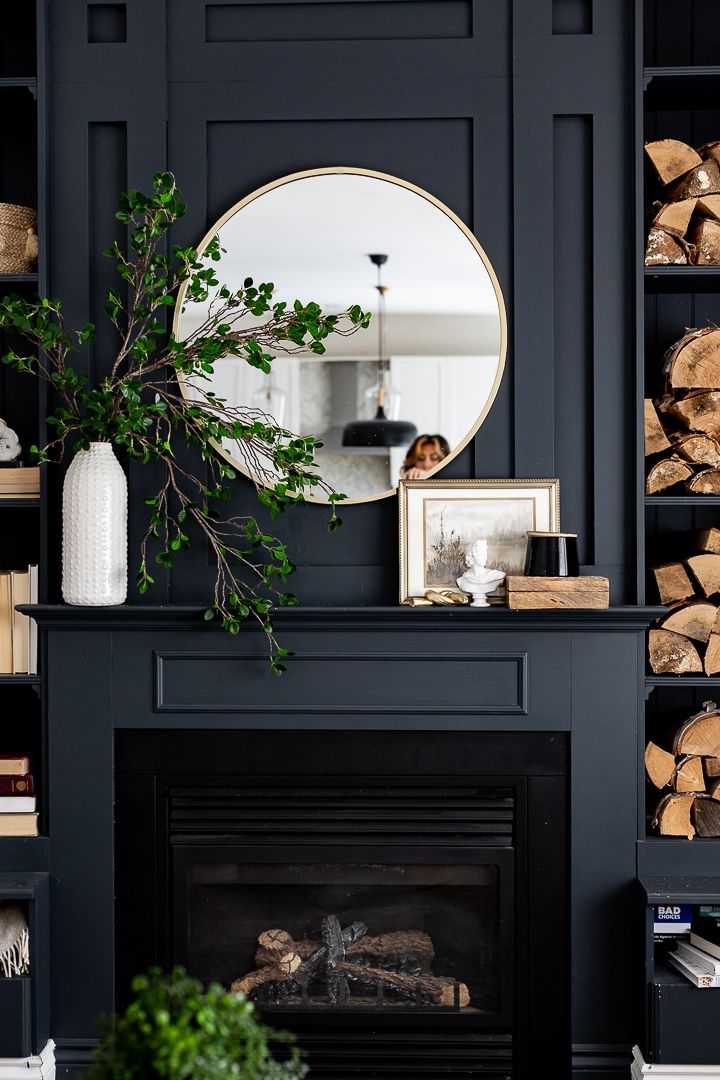 a living room filled with furniture and a mirror on top of a fireplace mantel