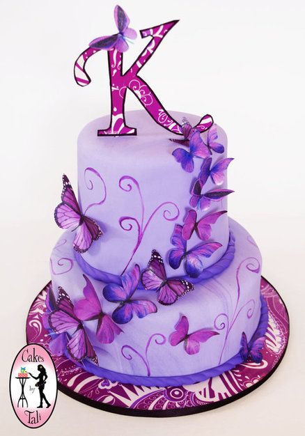 a purple cake with butterflies on it and the letter k in the middle is made out of fondant