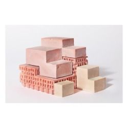 several blocks of pink clay stacked on top of each other in front of a white background