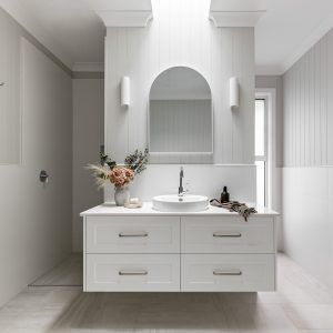 a white bathroom with two sinks and mirrors