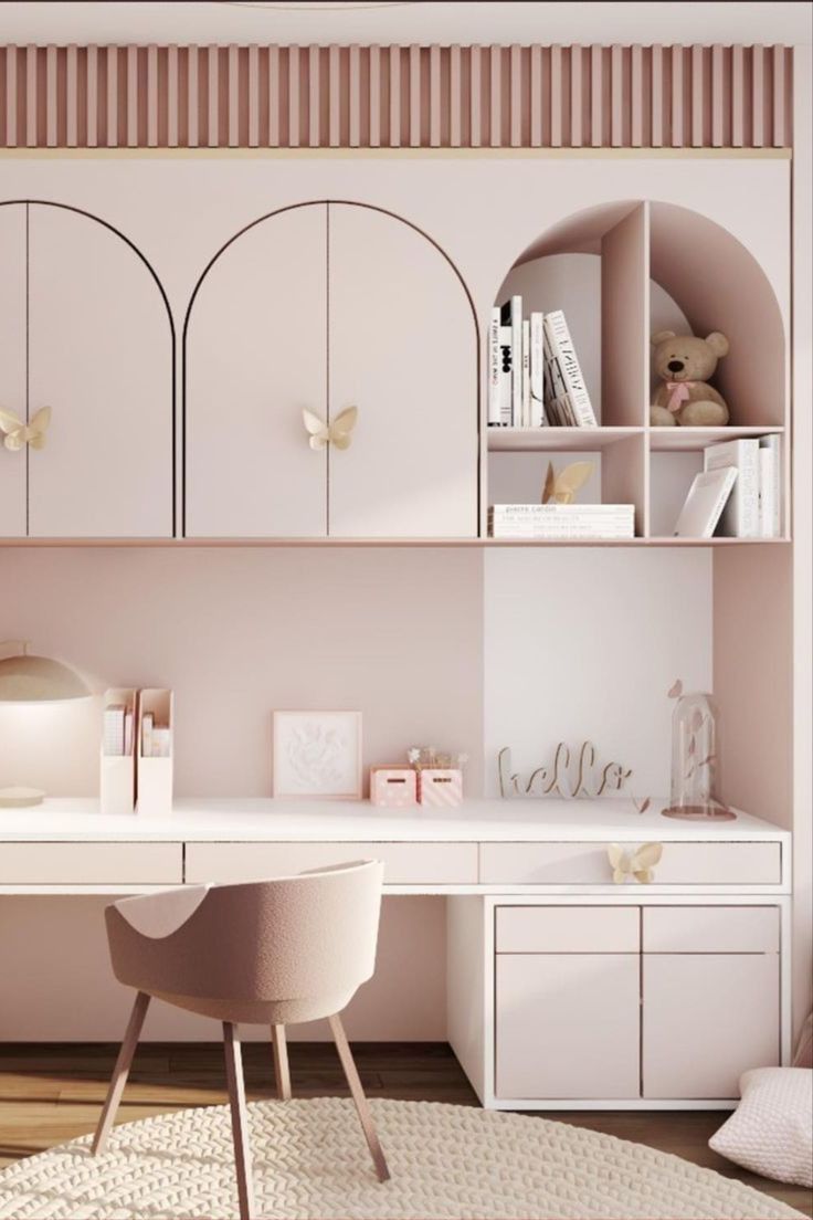 a white desk and chair in a room with pink walls, bookshelves and shelves