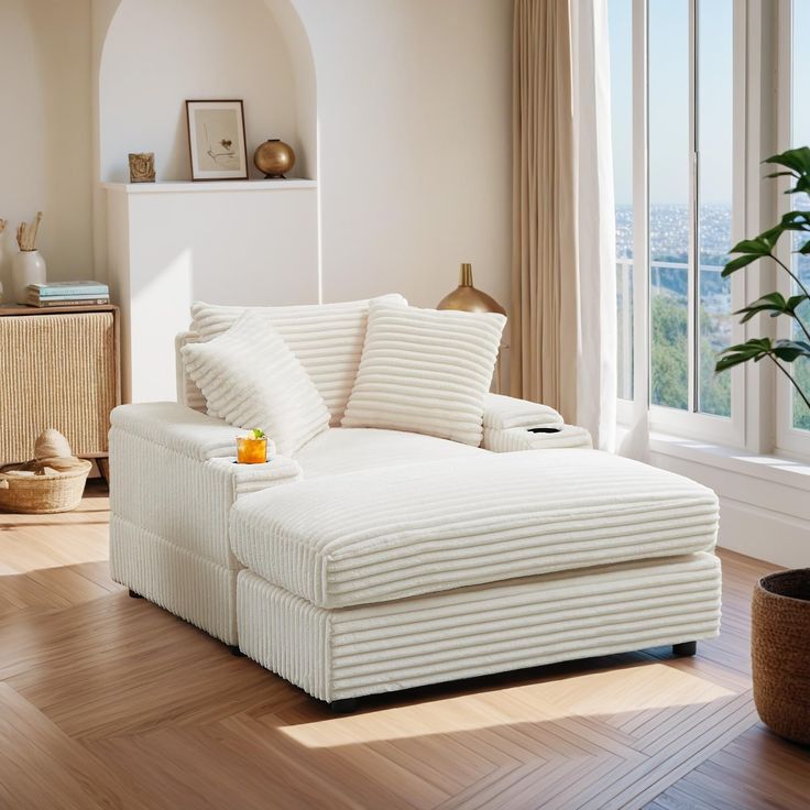 a living room with a white couch and wooden flooring next to a large window