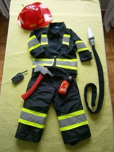 a fireman's uniform and helmet are laid out on the floor with tools