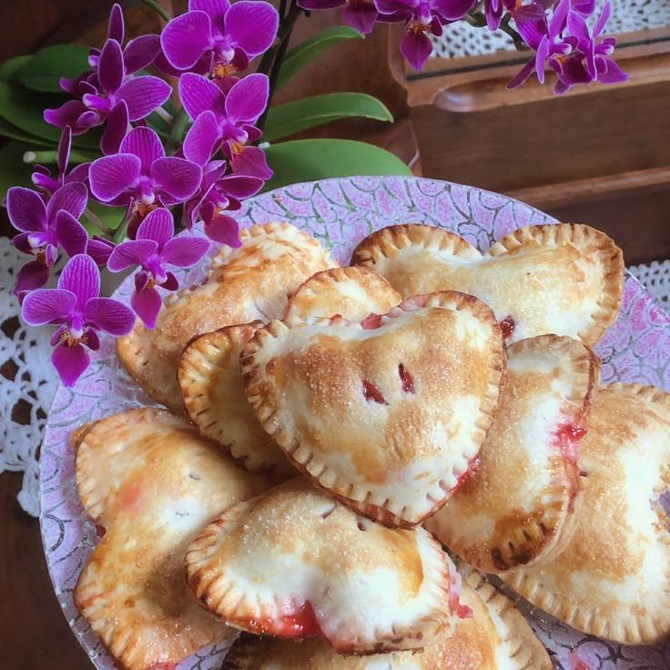 several pastries on a plate with purple flowers in the background