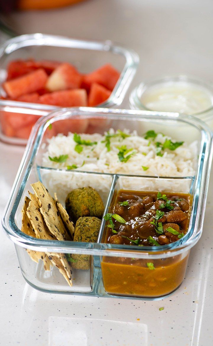 two plastic containers filled with food on top of a white counter next to each other