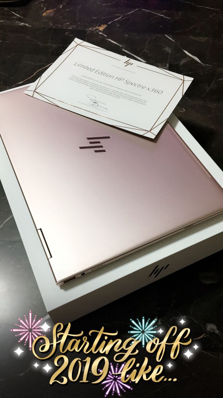 an open laptop computer sitting on top of a black table with fireworks in the background