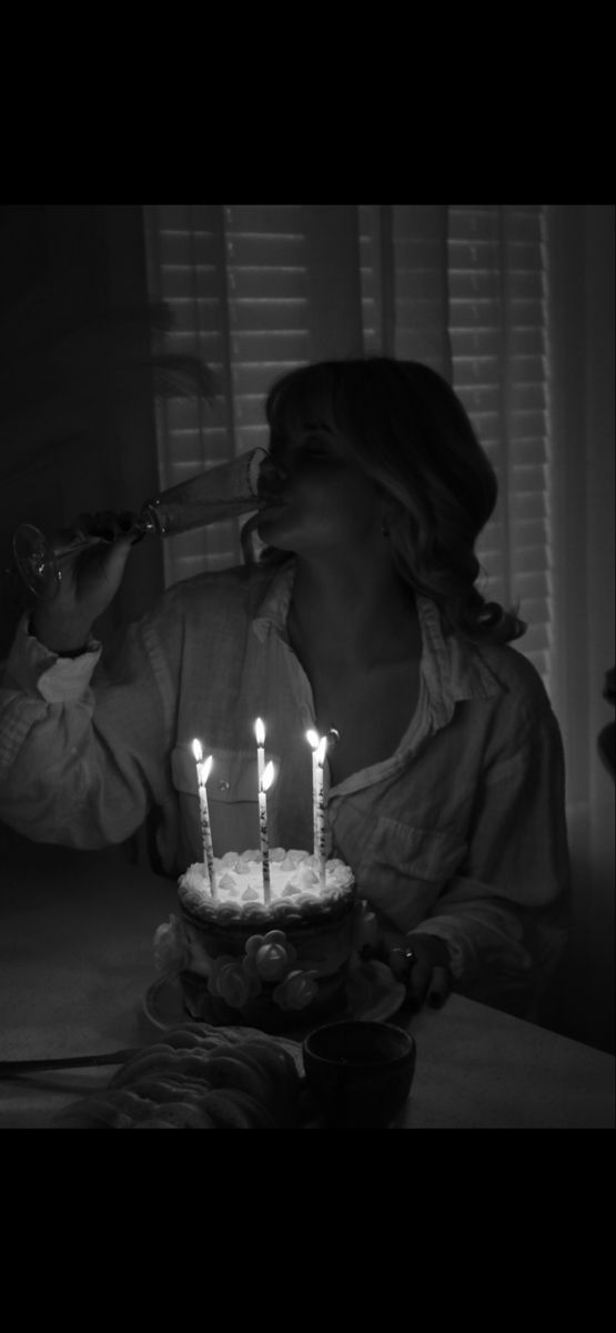 a woman blowing out candles on a cake