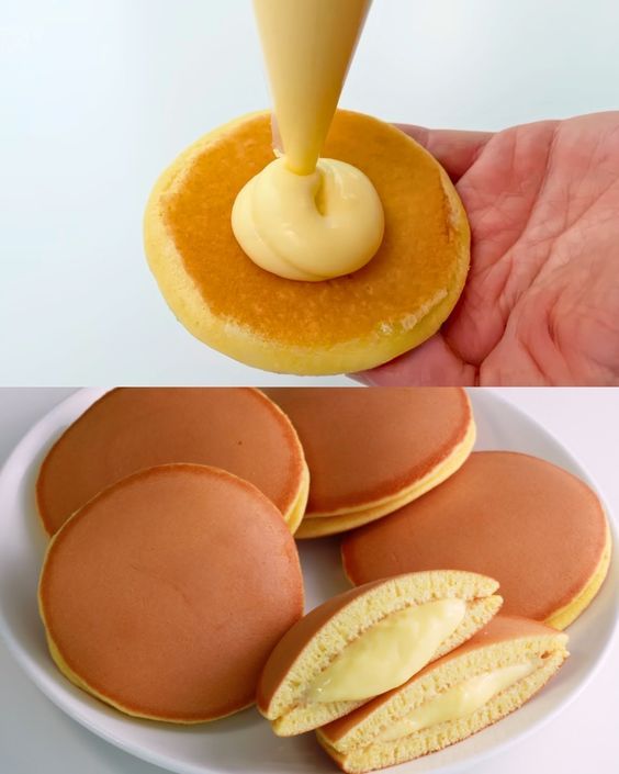 a person is pouring icing onto some pancakes on a white plate with other pastries