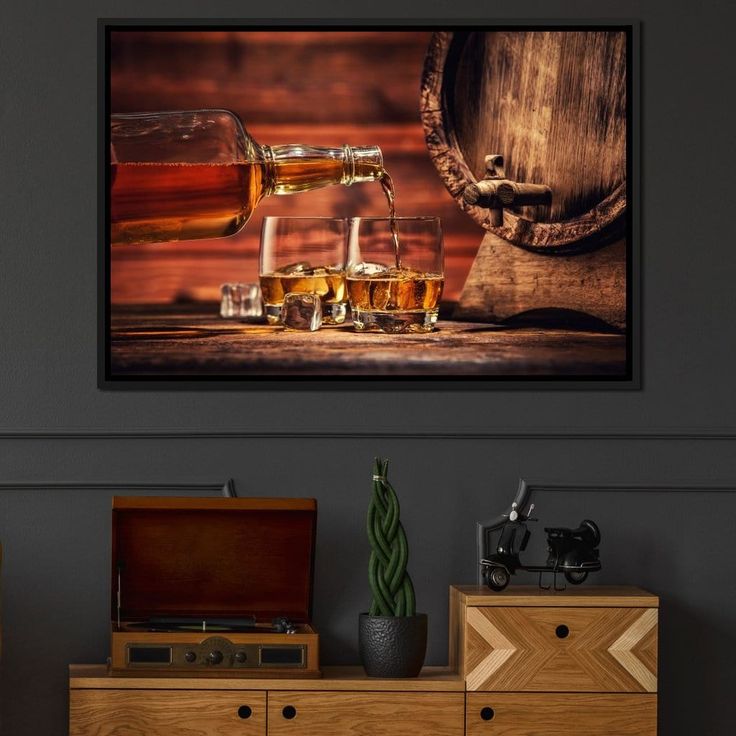 two glasses of whiskey are on the table next to an old barrel and wooden chest