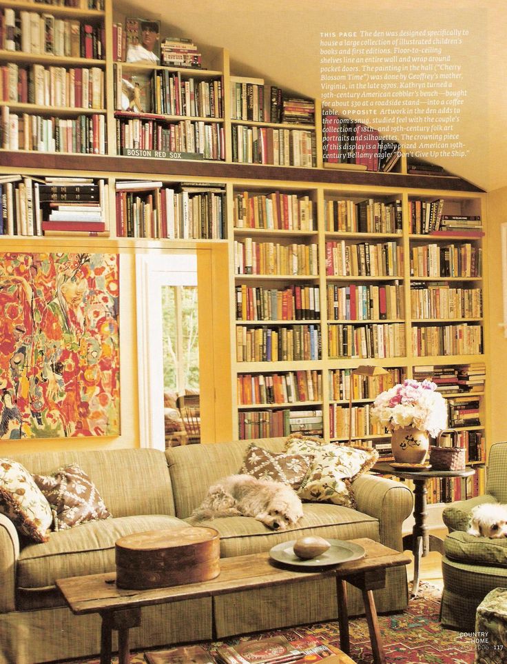 a living room filled with lots of furniture and bookshelves full of books on top of them