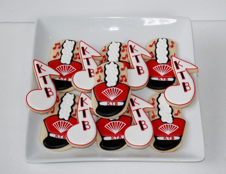 decorated cookies are arranged on a plate with red and white decorations, including fan shapes