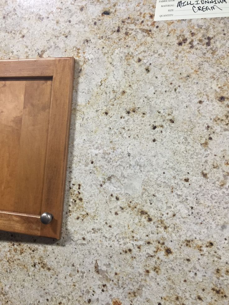 a kitchen counter top with a wooden cabinet on the left and a sign on the right