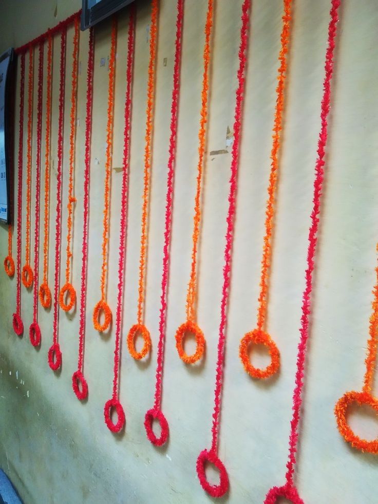 orange and red beads are hanging on the wall