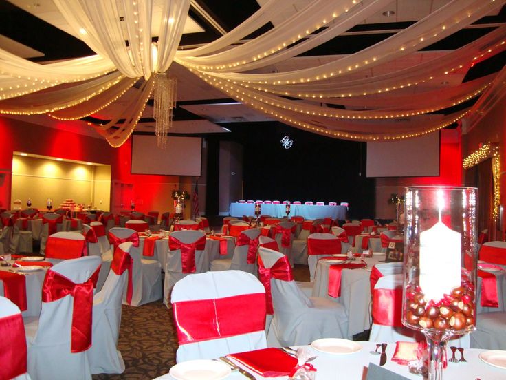 the banquet hall is decorated with red and white linens