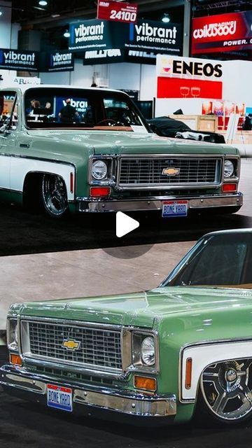 an old green car parked in front of a truck on display at a showroom