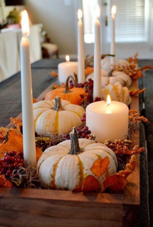 a table with candles and pumpkins on it