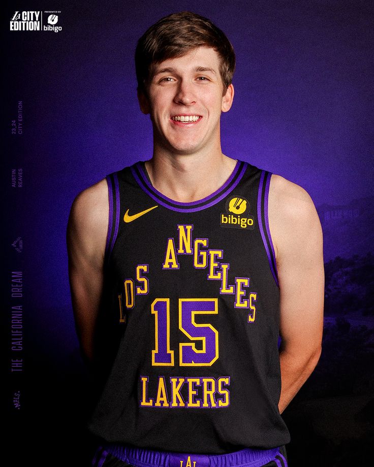 a young man wearing a black and purple basketball uniform with the number 15 on it