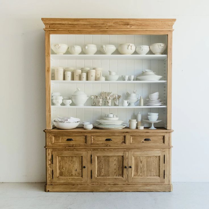 a wooden china cabinet filled with white dishes