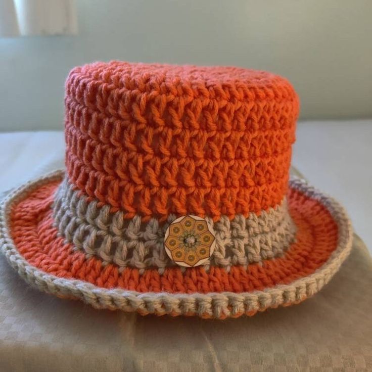 an orange and white crocheted hat sitting on top of a table