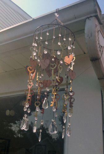 a wind chime hanging from the side of a house with lots of keys attached to it