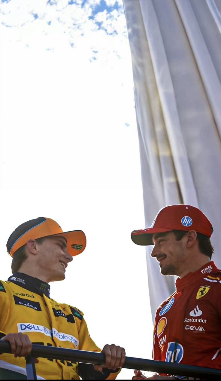 two men standing next to each other in front of a white curtain with the words nascar on it