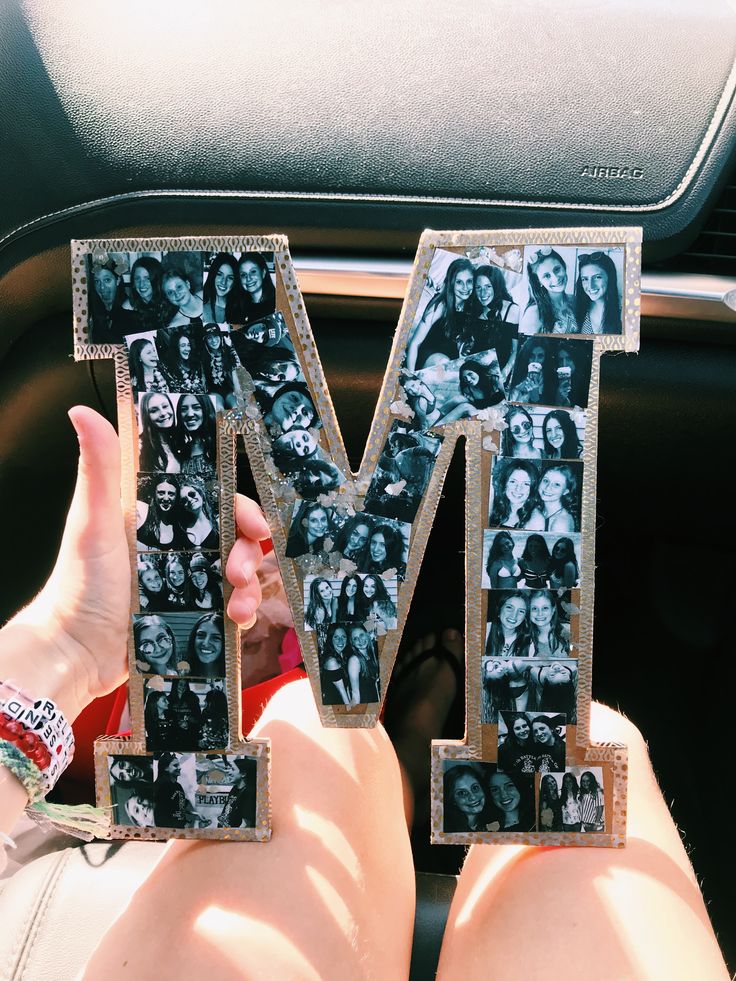 someone holding up the letter m in their hand with pictures on it and people's faces