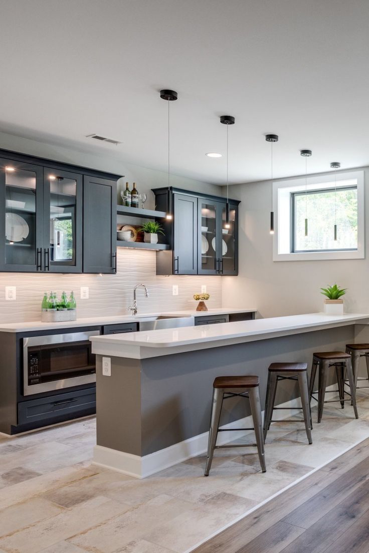 a large kitchen with an island in the middle and bar stools at the end