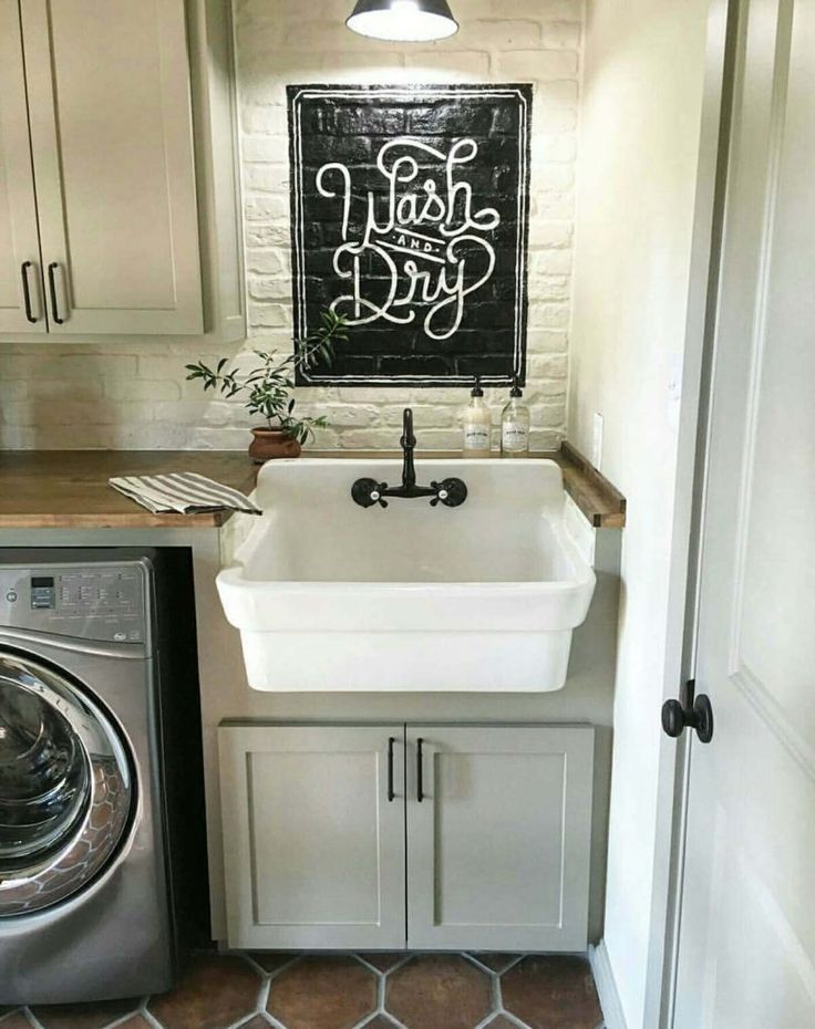 a washer and dryer in a small room next to a doorway with a chalkboard on the wall