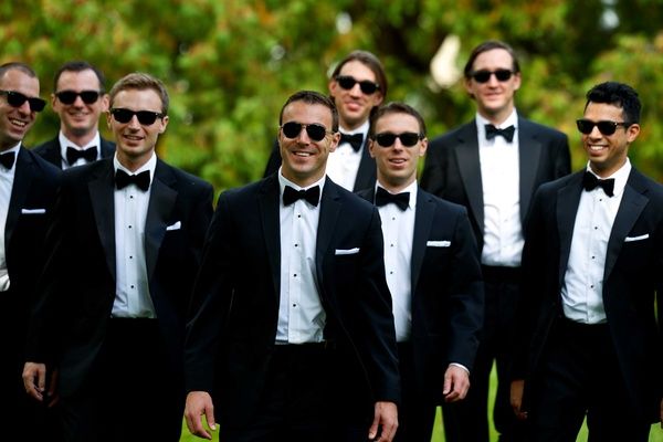 a group of men in tuxedos standing next to each other with sunglasses on