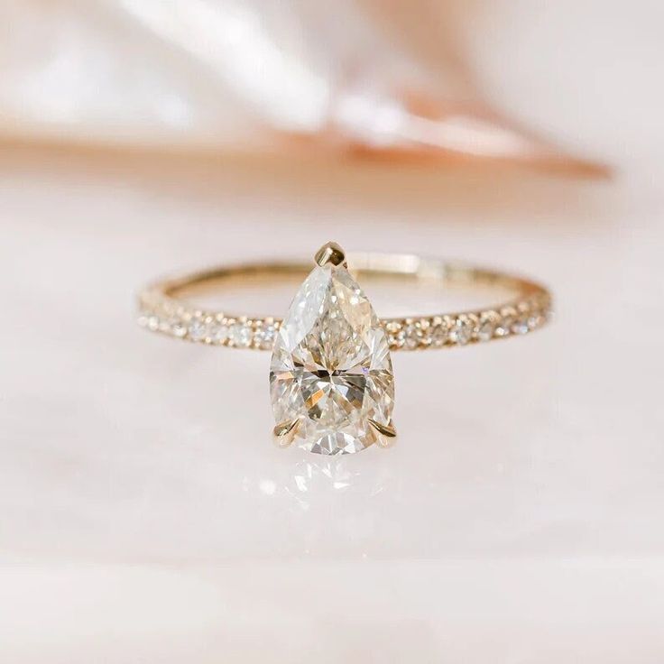 a white diamond ring sitting on top of a table