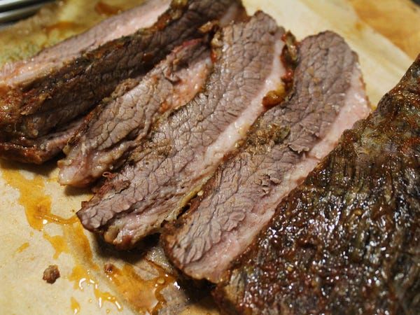 sliced meat sitting on top of a cutting board