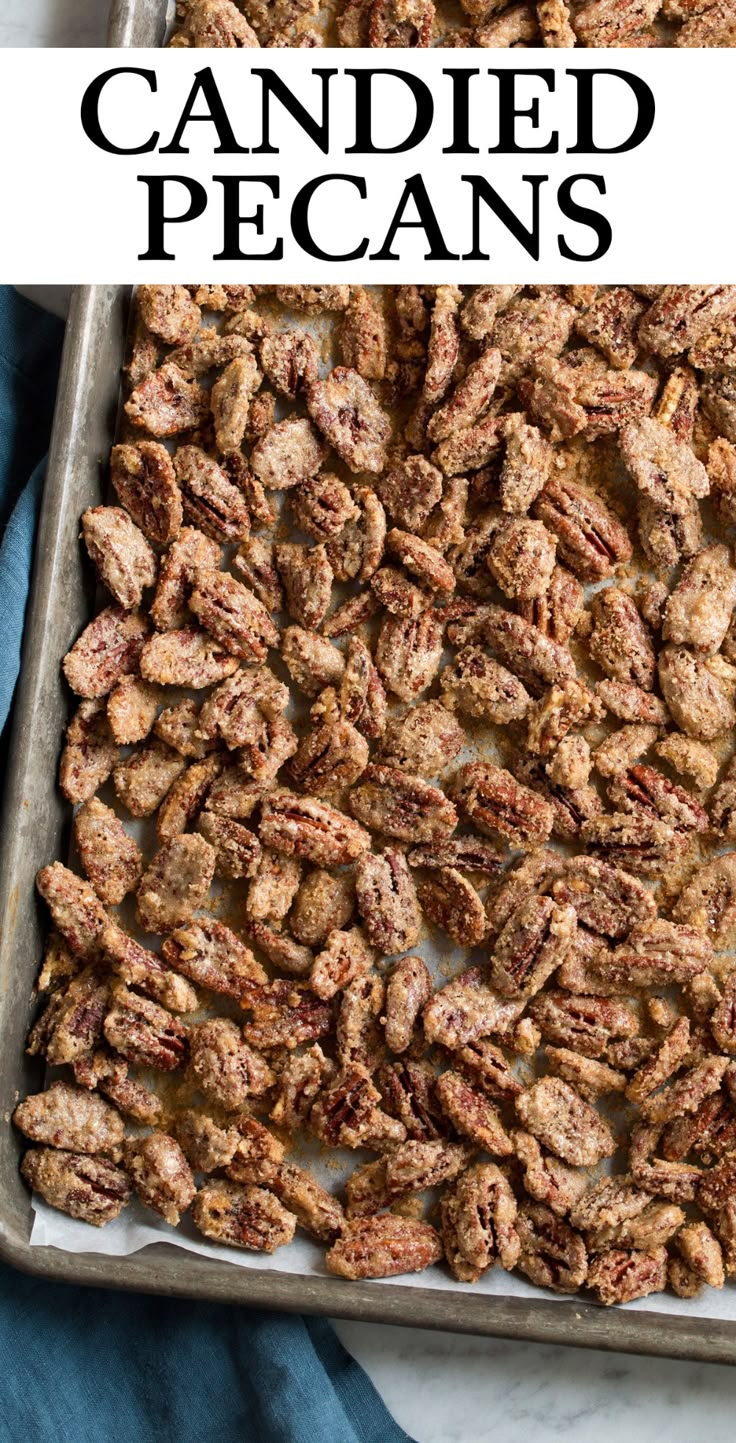 a pan filled with candied pecans sitting on top of a blue towel