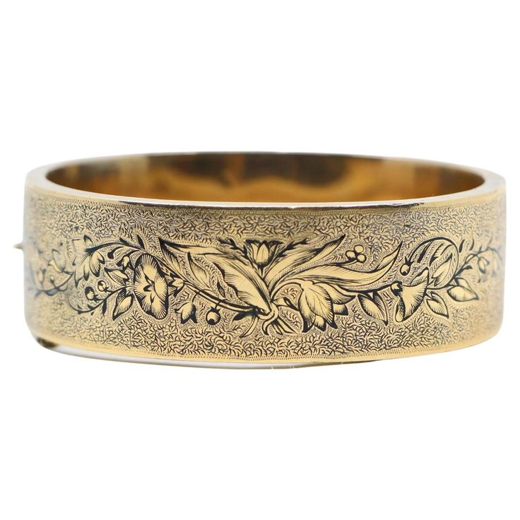 Victorian Engraved Enamel 14K Gold Bangle Bracelet Hand fabricated in 14K gold, thia Victorian hinged bangle is embellished with a hand-engraved texture and a graceful flowering vine that winds around its length along with a Black enamel tracery. Approximate Dimensions: 15.8 cm (Inner Circumference) 2 cm(Width) 32.4 grams in weight. Luxury Antique Cuff Bracelet, Luxury Gold Cameo Bracelet, Luxury Victorian Jewelry With Decorative Band, Luxury Heirloom Adjustable Cuff Bracelet, Luxury Antique Bracelets With Intricate Design, Luxury Gold Ornate Bangle, Luxury Vintage Cuff Bracelet Gift, Luxury Vintage Gold-tone Bracelet, Affordable Vintage Bangle As Gift