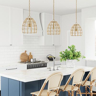 a kitchen with blue and white cabinets, marble counter tops, and gold pendant lights hanging from the ceiling