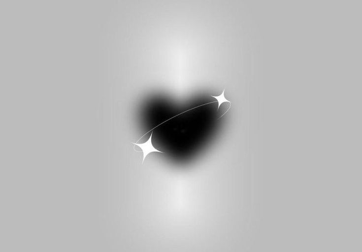 a black heart shaped object with white stars on it's side, in front of a gray background