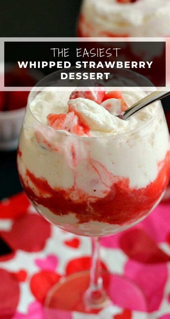 a dessert with whipped cream and strawberries in it on a pink table cloth next to two glasses