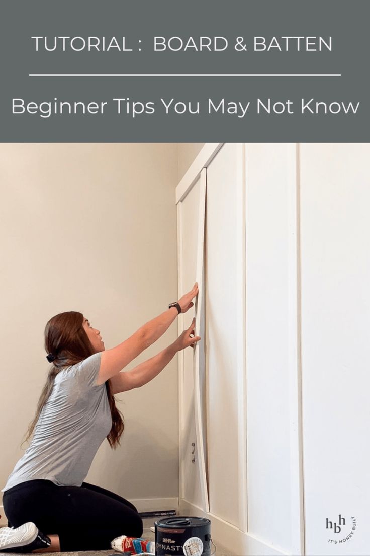 a woman is painting the wall with white paint and she has her hands on the door