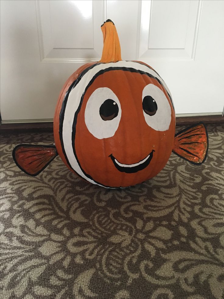 an orange and white clown fish pumpkin sitting in front of a door