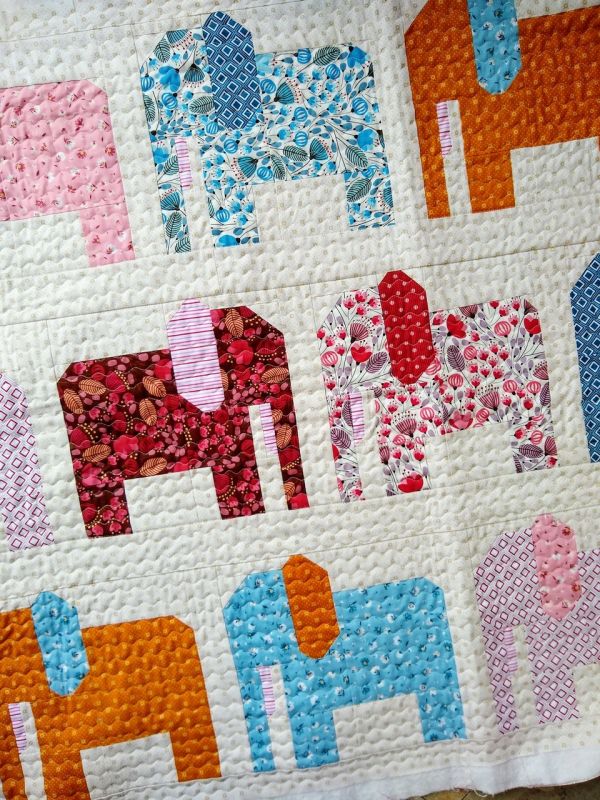 an elephant quilt is displayed on a table