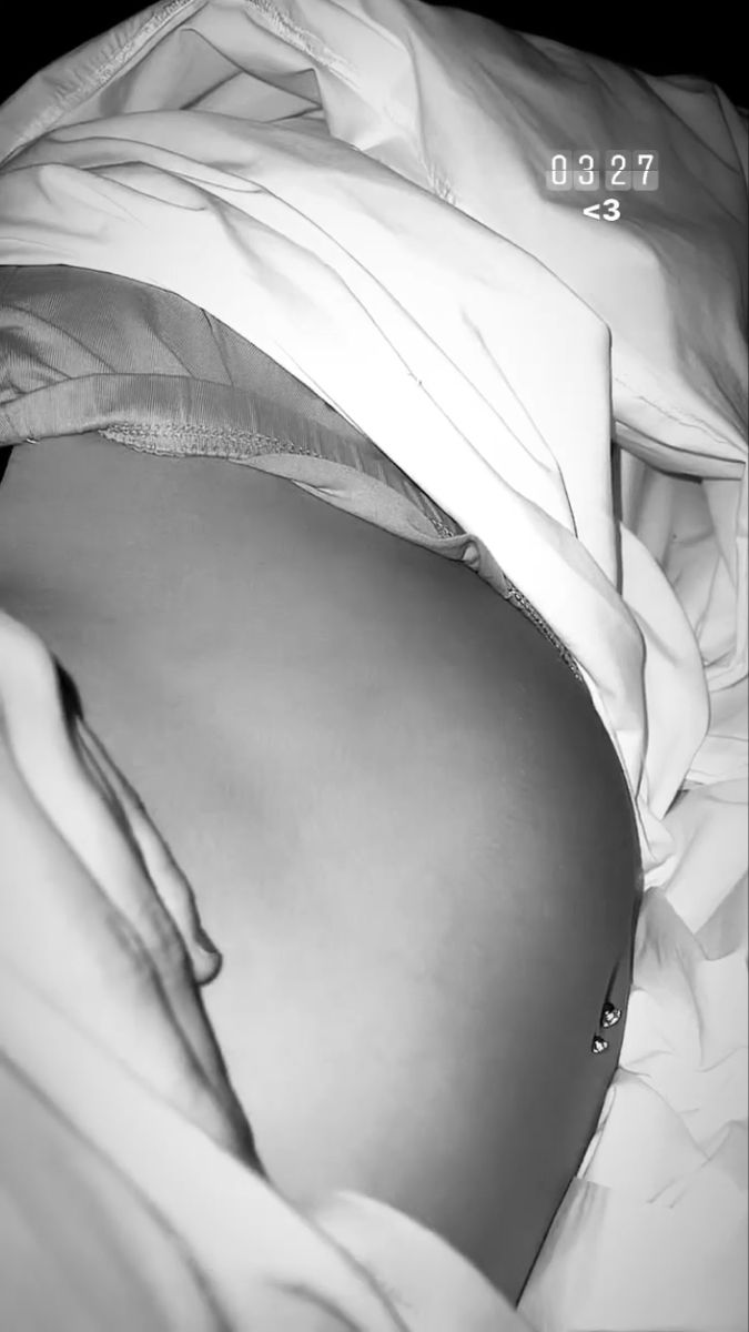 a black and white photo of a pregnant woman's stomach with the number 9202 on it