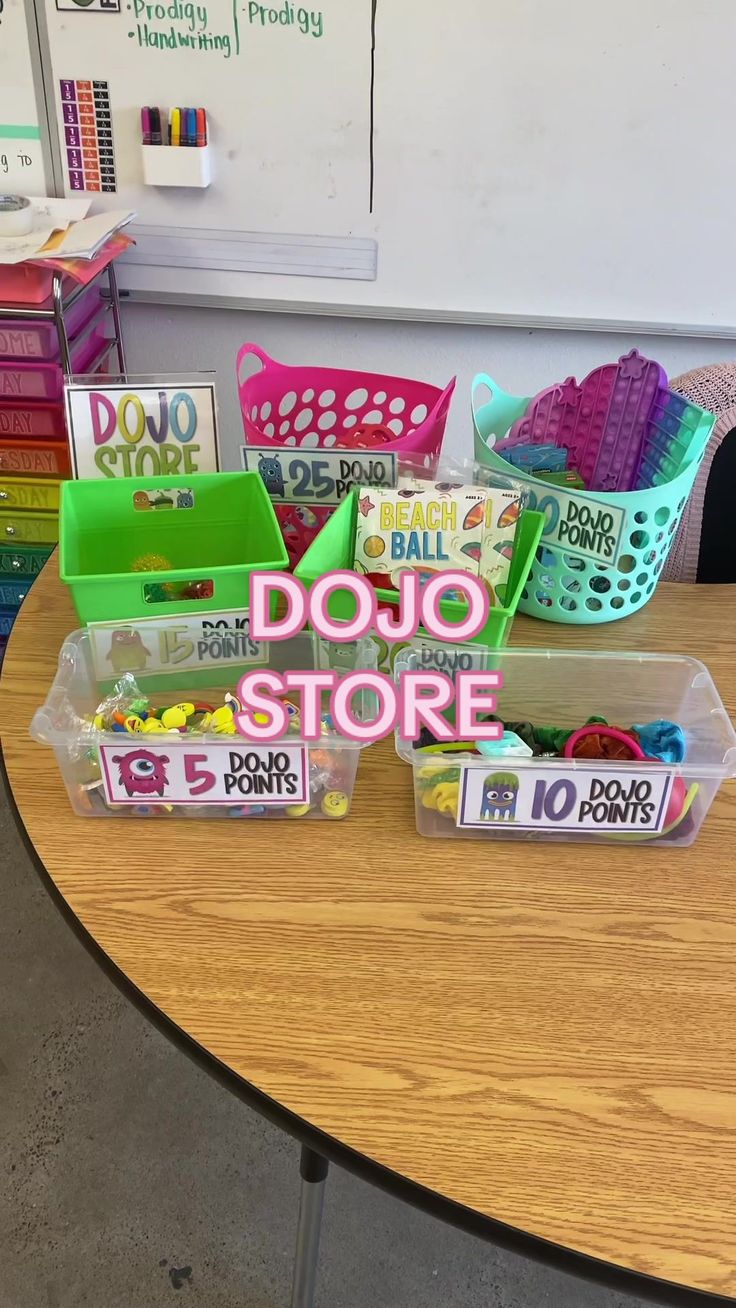 plastic bins filled with different types of items on top of a table in front of a whiteboard