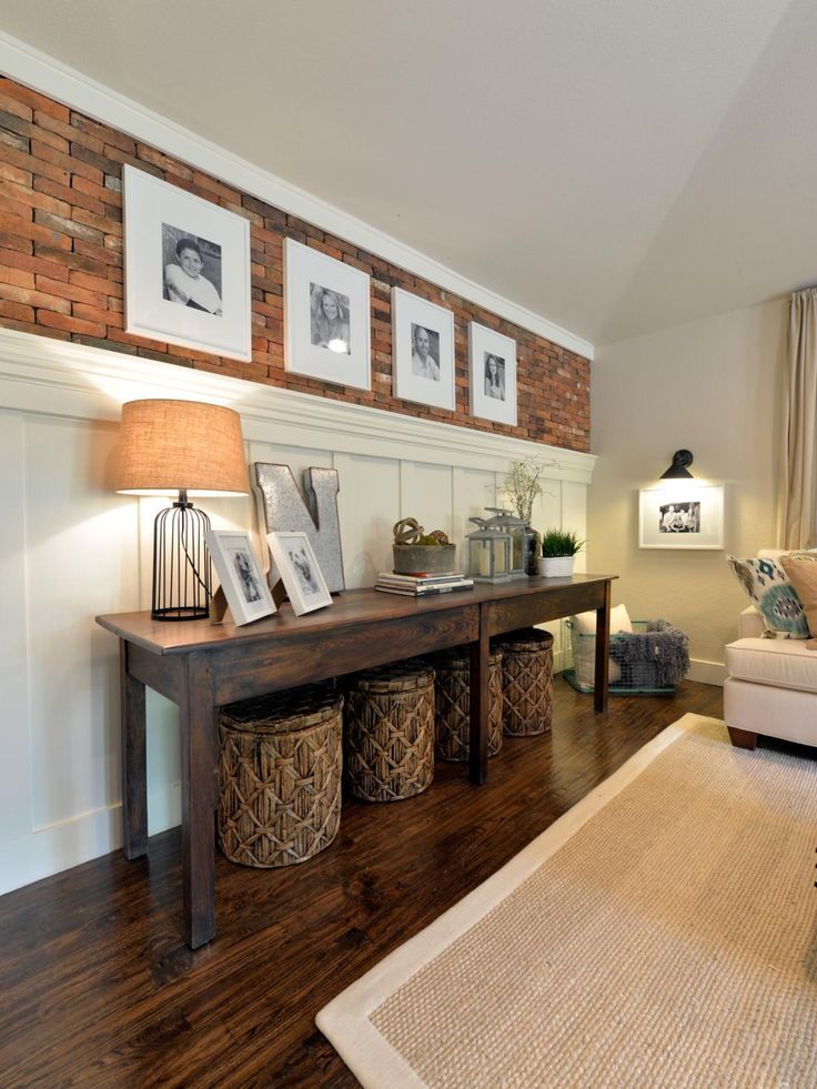 a living room with pictures hanging on the wall and two baskets under the coffee table