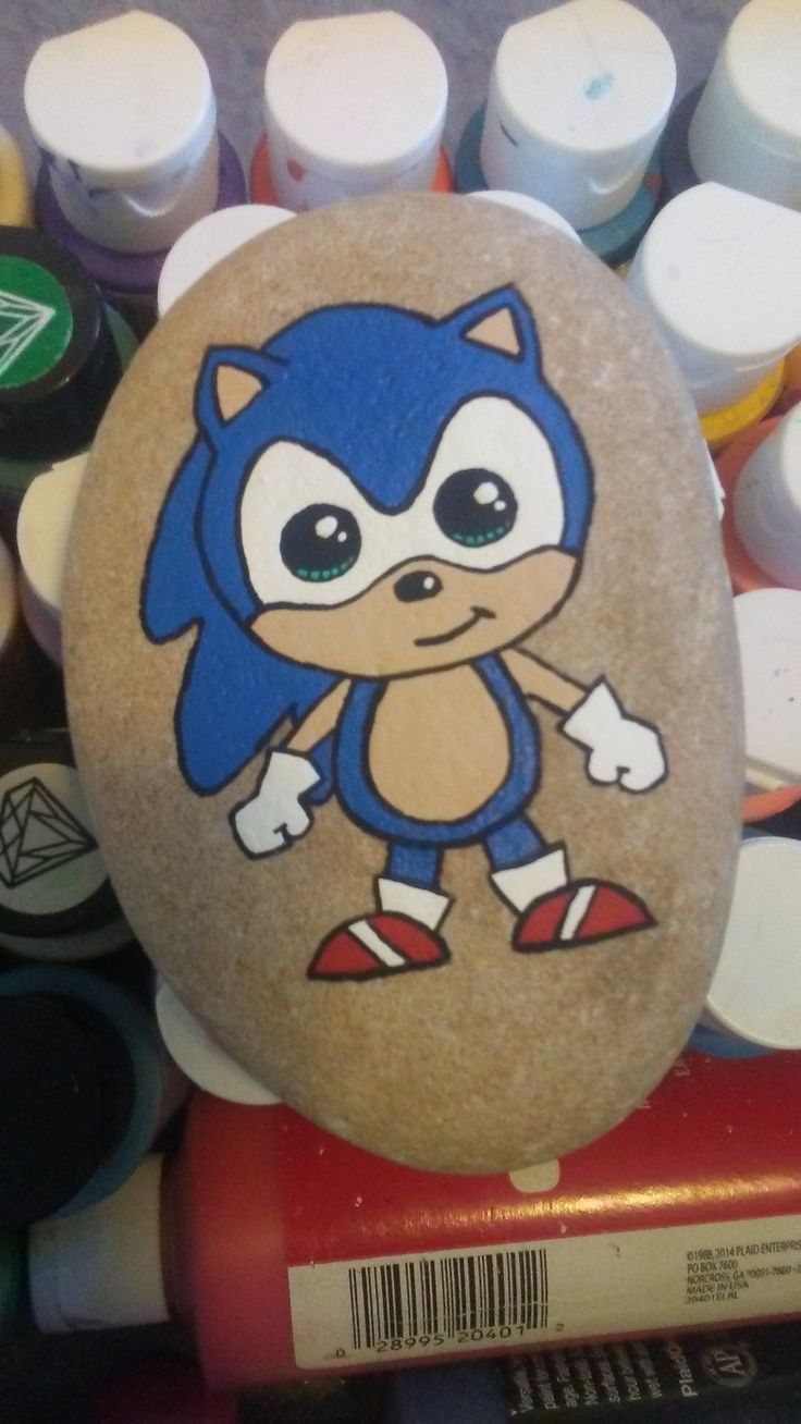 a rock painted with an image of a cartoon character on it, surrounded by markers