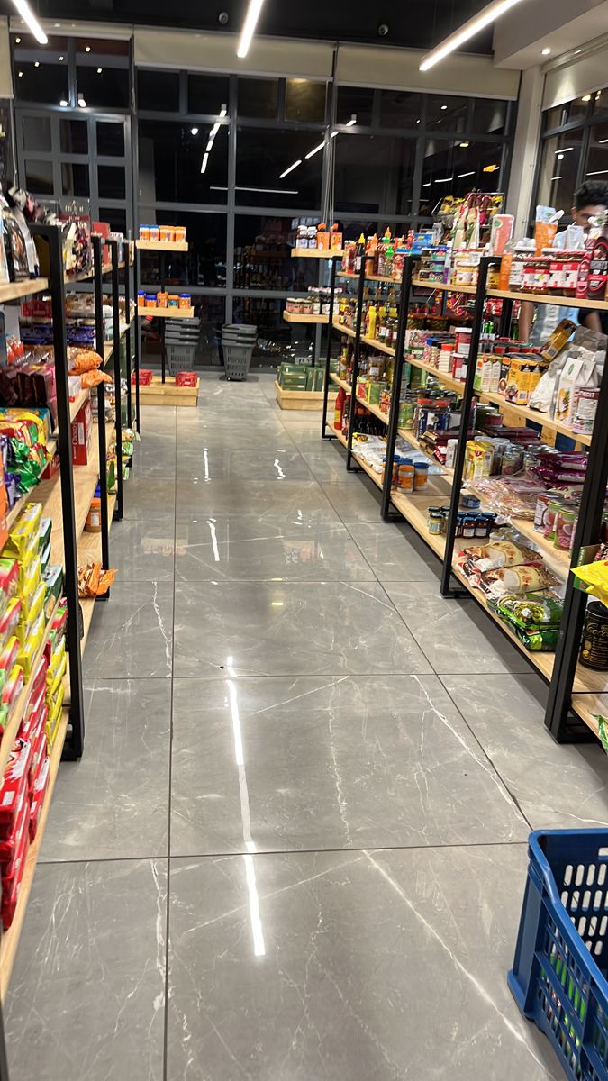 an empty grocery store aisle with shelves full of food and drinks on the sidelines