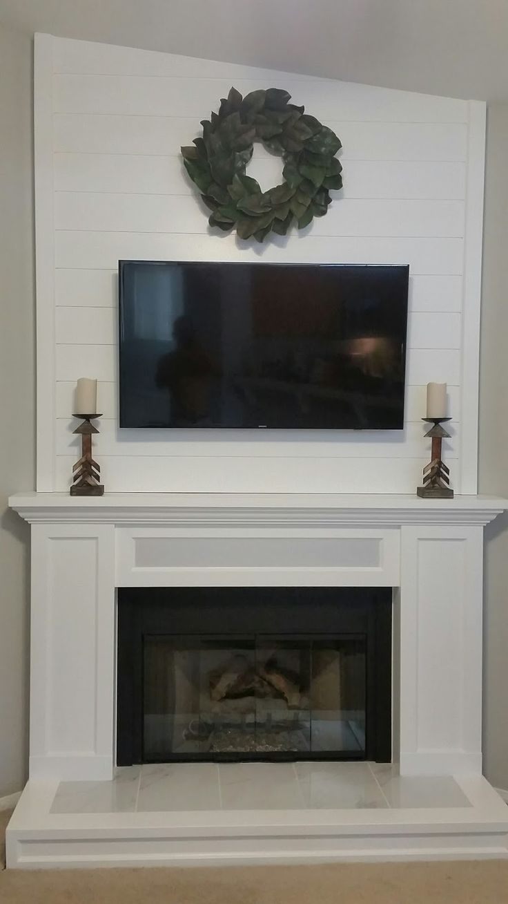 a fireplace with a flat screen tv mounted on it's wall above the mantle