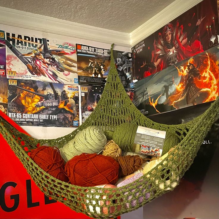 there is a hammock with balls of yarn in it and posters on the wall