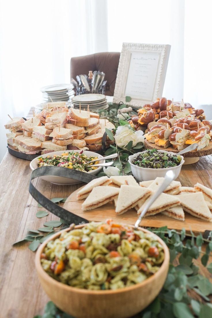 a wooden table topped with lots of plates and bowls filled with different types of food