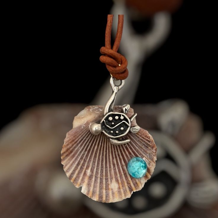 "Embrace the enduring qualities of the turtle and the serenity of the sea with this delightful necklace. The turtle symbolizes longevity, perseverance, and wisdom, offering you guidance and strength. The seashell brings a sense of tranquility and connection to the ocean, reminding you to stay grounded and peaceful and amidst life's waves. Wear this necklace as a reminder of these qualities in your daily life. Ocean-inspired Adjustable Necklace As A Gift, Adjustable Ocean-inspired Necklace For Gifts, Adjustable Ocean-inspired Necklace For Gift, Spiritual Turtle-shaped Jewelry Gift, Spiritual Turtle Shaped Jewelry Gift, Adjustable Ocean-inspired Shell Pendant Necklace, Spiritual Shell Necklace Gift, Adjustable Ocean-inspired Round Pendant Jewelry, Spiritual Shell Necklaces As Gift